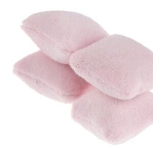 Four soft, pink plush pillows stacked, isolated on a white background.