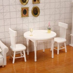 Miniature dining set with two chairs, a round table, a drink, and art on a tiled wall.