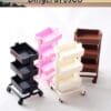 Four mini rolling carts in black, pink, white, and brown with three shelves each.