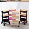 Four mini trolley carts in black, pink, white, and brown with wooden tops on wheels, displayed on a white background.