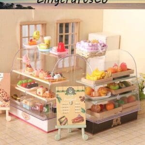 Miniature bakery display with assorted pastries and fruits under clear domes, featuring a small menu sign.