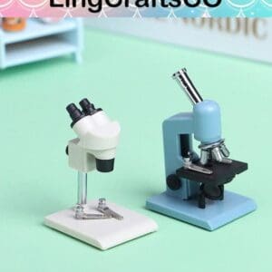Two miniature microscopes, one white and one blue, on a light green surface with LingCraftsCO text above.