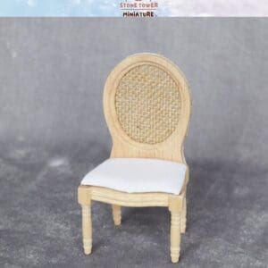 Miniature wooden chair with oval woven back and white cushioned seat on a gray background. Stone Tower Miniature logo above.