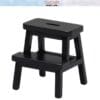 Black miniature wooden step stool with two steps, displayed against a white background.