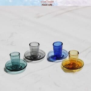 Colorful miniature glass tea sets on a white marble surface.