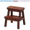 Miniature wooden step stool with two levels, featuring a slot on the top surface, isolated on a white background.