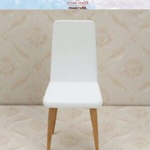 White miniature chair with wooden legs on a patterned beige background, under a light blue sky with a logo.
