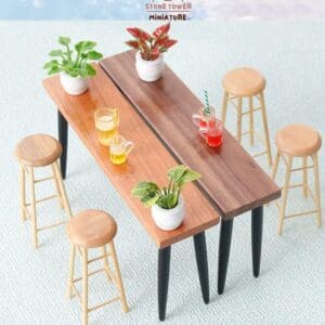 Miniature wooden tables with plants and drinks, surrounded by small wooden stools on a light blue carpet.