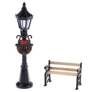 Miniature black lamppost with wreath and a small wooden bench on a white background.