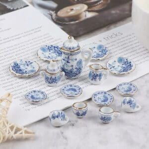Miniature blue and white porcelain tea set on a marble surface beside an open magazine.