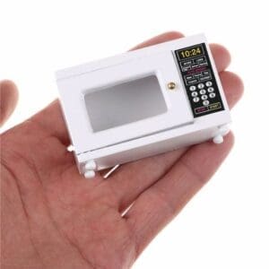 Miniature microwave replica held in a person's hand; white with a detailed control panel.