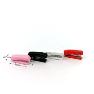 Four mini staplers in pink, black, white, and red, displayed vertically with measurements indicated.
