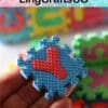 Hand holding an interlocking foam puzzle piece with a red letter Y, colorful pieces in the background.