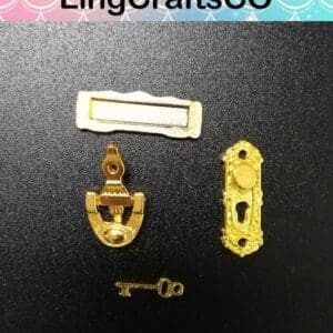 Miniature gold key, knocker, nameplate, and keyhole plate on a black background from LingCraftsCO.