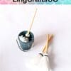 Miniature cleaning set with a small blue bucket and three tiny mops on a white background.