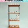 Wooden shelf with rows of small, decorated glass jars by LingCraftsCO, displayed against a light green background.