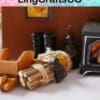 Miniature axe, sticks tied with twine, and a small stove on a tabletop with a colorful "LingCraftsCO" banner.