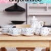 Miniature tea set with blue polka dots displayed on a wooden table in a kitchen setting.