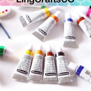 Tubes of Schmincke watercolor paint in various colors on a white surface with a colorful "LingCraftsCO" banner above.