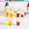 Miniature beer mugs with foam, yellow and brown drinks, on a white surface. Blurred background.