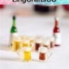 Miniature beer mugs with a blurred background featuring small bottles.