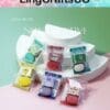 Colorful soap bars in cute packaging displayed on a white tiered platform with a pastel background.