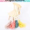 Four colorful mini brooms leaning against a small wooden chair with "LingCraftsCO" text above.