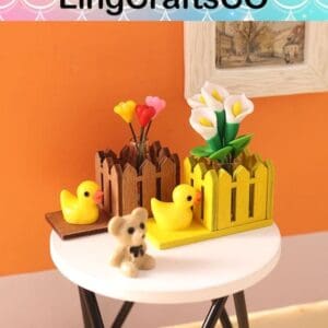 Miniature duck figurines and fencing with flowers on a round white table against an orange wall.