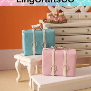 Two miniature pastel suitcases, one blue and one pink, placed on white furniture in a dollhouse setting.