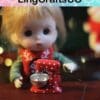 Doll with a red scarf sits at a table with a miniature red polka dot mixer.