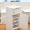 Miniature white refrigerator with three shelves and an open door in a dollhouse kitchen setting.