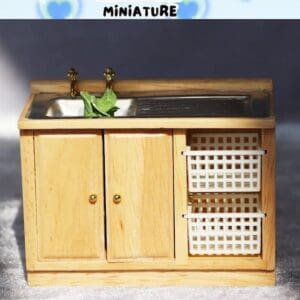 Miniature wooden kitchen sink with dual faucets, a leafy vegetable in the sink, and two side storage baskets.