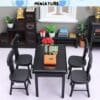 Miniature dining room set with a black table, four chairs, and a vase of red roses in a dollhouse setting.